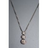 A three stone diamond pendant, the graduated vertically set cut diamonds in collar mounts to a box