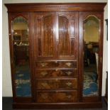 A late Victorian, three section mirror door compactum wardrobe fitted a central bank of drawers.