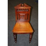 A single Edwardian mahogany hall chair, the architectural rail over pierced and floral panel back,