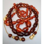 A graduated string of Amber type beads together with one other string of amber type beads. Note: