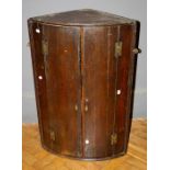 A small early 19th oak barrel fronted hanging corner cupboard. 90 x 59 cms.