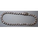 A diamond set line or tennis bracelet, the thirty eight stones mounted in white gold, stamped .750