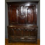 An 18th century oak livery cupboard, the moulded cornice over fielded panels and a pair of doors