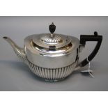 William Hutton and sons Ltd., an Edwardian silver teapot of demi gadrooned form with bakelite