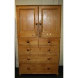 A Victorian stripped pine two door, house-keepers cupboard fitted two short drawers and three long