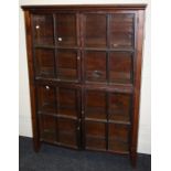 An early 20th century plain glazed two section painted pine bookcase with plain glazed doors.