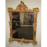 A 19th century carved giltwood wall mirror, the Rococo form frame enclosing a later plain