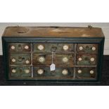 An 18th century-style bank of nine spice drawers with simple wire ring handles and printed labels.