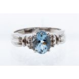 An aquamarine and diamond 18ct white gold ring, the central  claw set oval aquamarine weighing