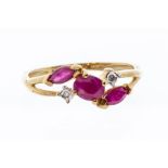 A ruby and diamond 9ct gold dress ring, set to the centre with a oval ruby, two marquise rubies