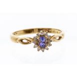 A tanzanite and diamond 9ct yellow gold ring, the central oval claw set tanzantite, weight approx