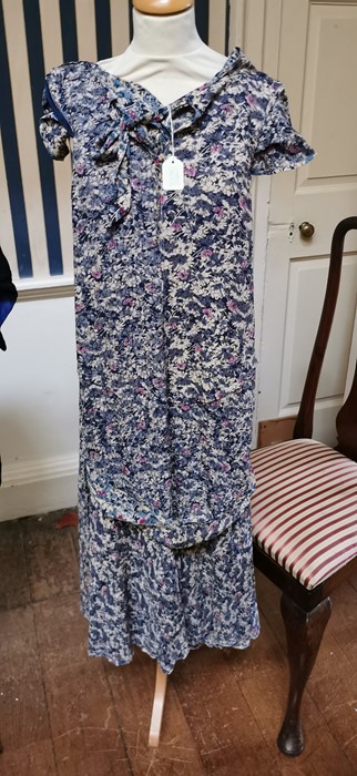 A 1930s blue floral dress with a beige/cream and cerise pink floral design on a blue background.