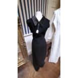 A black evening gown in fine jersey, shift design, with a satin rolled collar, at the front and
