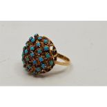 An 18ct. gold and turquoise dress ring, having lattice wire work mount claw set numerous round