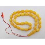 A string of yellow amber beads, of oval form, each approx. length 17mm x diameter 12mm, with
