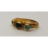 An Indian precious yellow metal and turquoise ring, having three graduated cabochon turquiose in rub