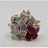 An 18ct. white gold, diamond and ruby cluster ring, claw set fifteen marquise cut diamonds, numerous