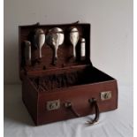 A leather cased ladies' travelling vanity set, fitted for, and containing a five piece silver