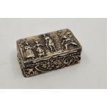 A late 19th century continental white metal snuff box, the lid repousse with figures in a rural