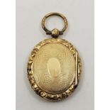 A Victorian yellow metal double oval locket, engine-turned with pinchbeck frame.