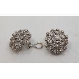 A pair of white gold diamond cluster earrings, of flower head form, each claw set nineteen round