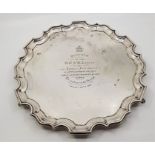 A silver circular presentation salver, by Josiah Williams & Co, London 1921, with scroll rim, raised