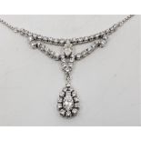 An 18ct. white gold diamond pendant necklace, set marquise cut diamond to centre between rows of