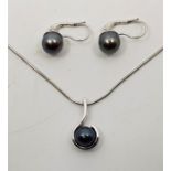 A Zlatarna Celje 14ct. white gold and black cultured pearl pendant, suspended from 14ct. white