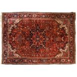Heriz rug, red ground covered in flowering stems around a floral medallion, black