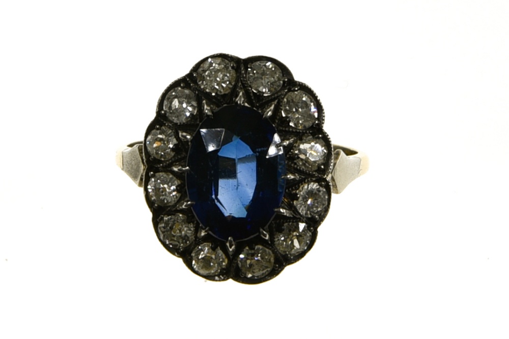 Daisy sapphire ring +/- 2.7 ct 18 kt yellow and white gold, set with a blue +/- 2.7 ct oval