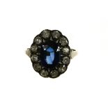 Daisy sapphire ring +/- 2.7 ct 18 kt yellow and white gold, set with a blue +/- 2.7 ct oval