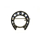 Horseshoe brooch 18 kt yellow gold and silver, depicting a horseshoe set with 9 sapphires of