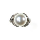 White pearl ring 18 kt white gold set with a white +/- 12.9 mm pearl flanked by two leaves set with
