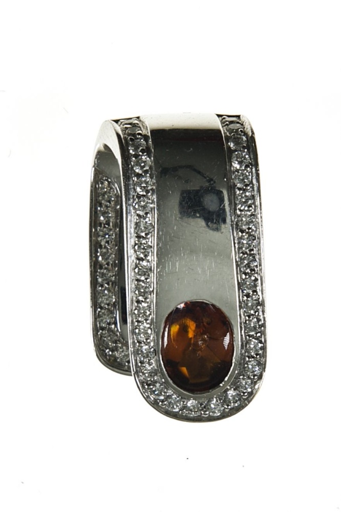 Pendant 18 kt white gold, set with an orange oval citrine cabochon (one dent) with a border of tiny