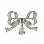 Bow brooch 18 kt white gold, depicting a bow set with small brilliants, 2 small calibrated emeralds