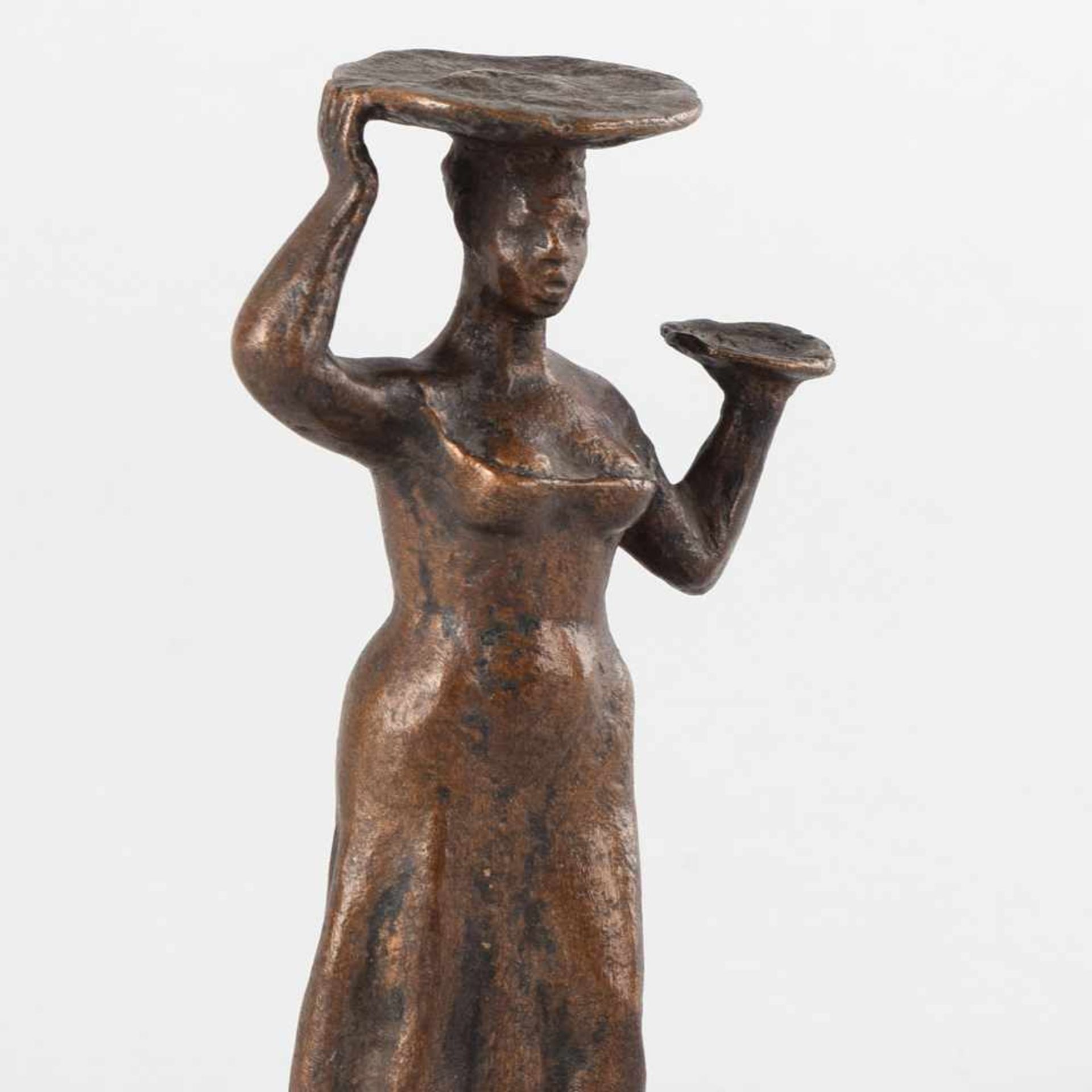 Kleinbronze in Braun patiniert, Standfigur einer jungen Frau, auf dem Kopf und mit der linken Hand