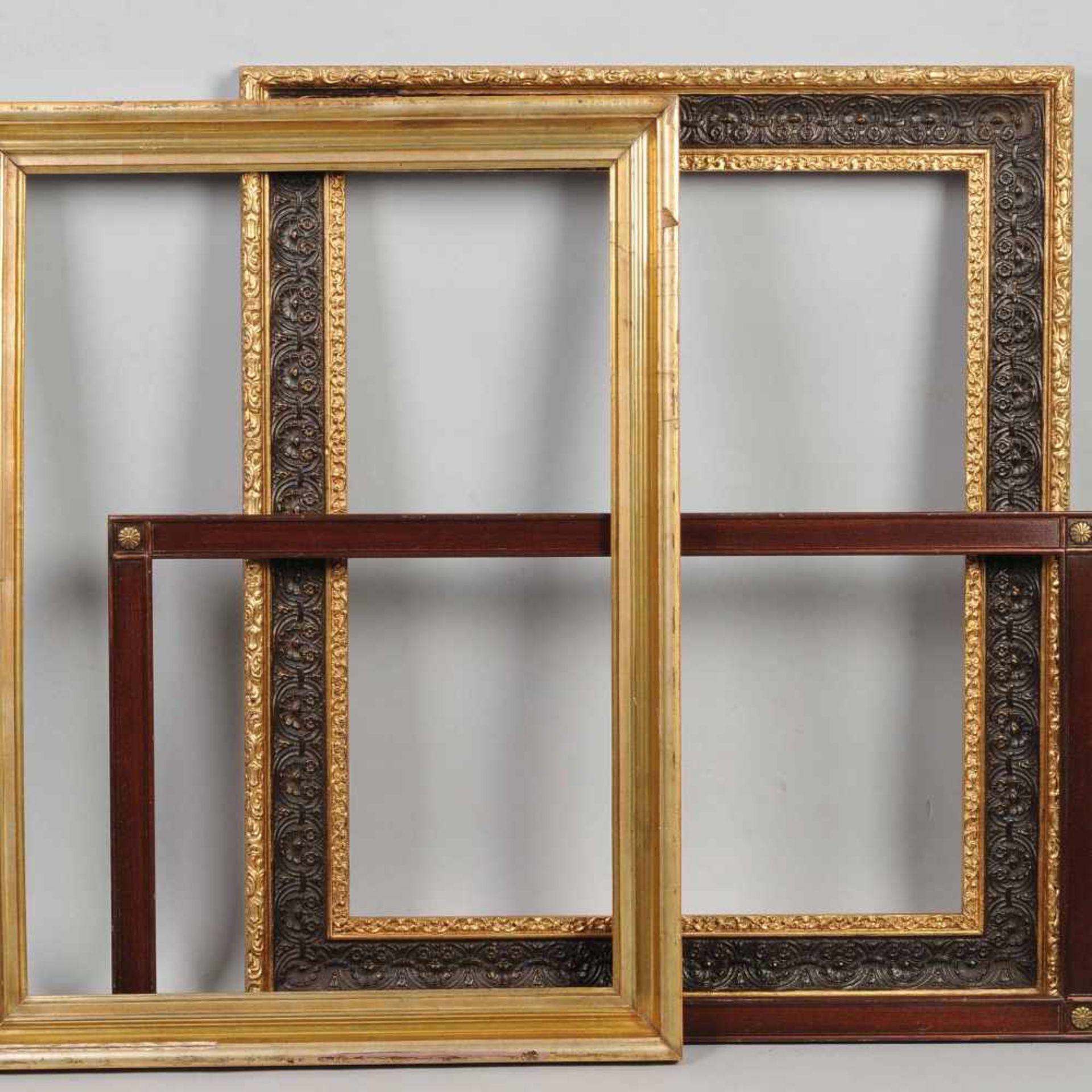 Drei Rahmen je Holz, 1 x goldlackiert, profiliert, 1 x dunkelbraune Farbgebung, Metallrosetten in