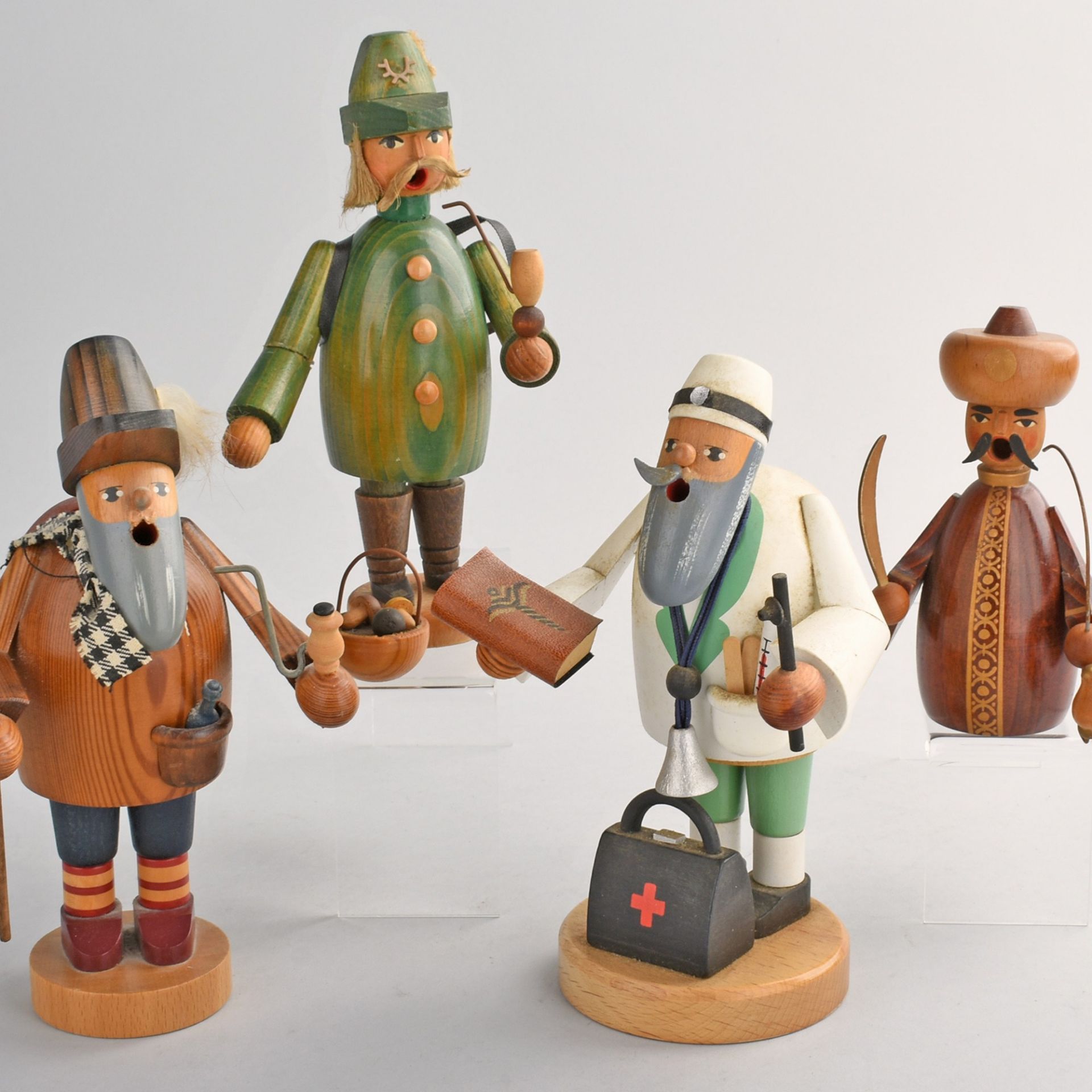 Vier Räuchermänner Holz gedrechselt, farbig gestaltet, unterschiedliche Darstellungen, teilweise