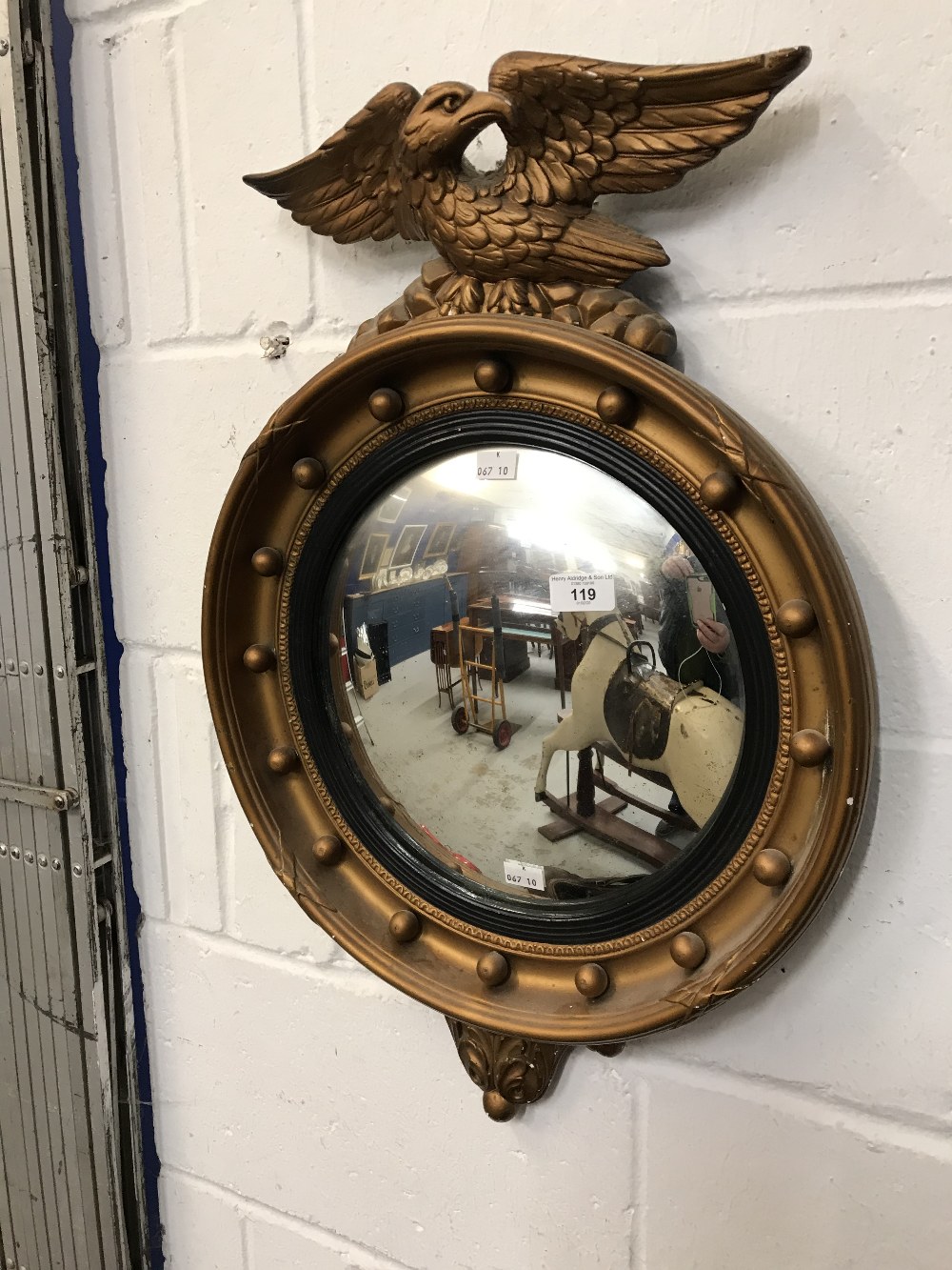 20th cent. Regency style gilt convex mirror with eagle mounted to the top. 26ins.