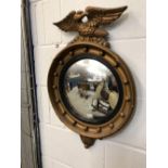 20th cent. Regency style gilt convex mirror with eagle mounted to the top. 26ins.