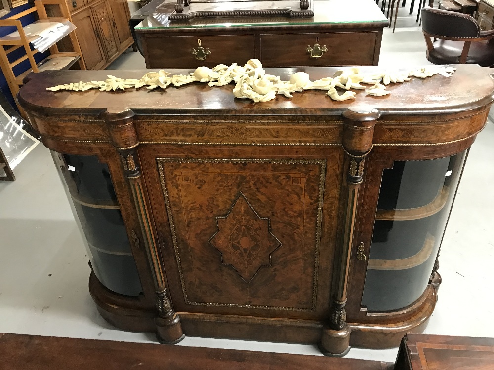 19th cent. Burr walnut credenza with bowed end doors. The central door is decorated with a brass and