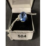 White Metal Jewellery: Ring set with a 19mm x 12mm blue topaz, tests as silver. Weights 6g.