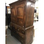 18th cent. Oak press cupboard with canted sides on a chest of 5 short and 1 long drawer, with 3
