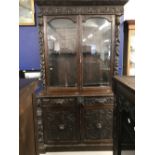 19th cent. Gothic style heavily carved dark oak bookcase with two doors and two drawers beneath.