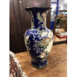 20th cent. Ceramic umbrella stand, blue ground decorated with flowers.