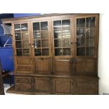 20th cent. Large oak display cabinet. Four glazed doors above, three doors and two drawers. 8ft.