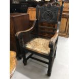 Victorian carved oak Jacobean style Wainscot armchair with straw seat.