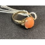 Jewellery: Yellow metal ring set with an oval cabochon cut coral, stamped 14k 585 tests as 14ct.