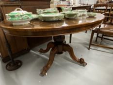 Victorian rosewood tilt top oval dining table on a baluster pedestal and four scrolled feet. 56¾