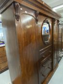 19th cent. Mahogany three section compactum with mirrored door over three drawer central section,